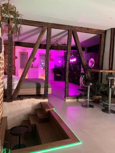 Cette chambre dispose d'un lit avec des lumières violettes. dans l'établissement Love Room Toulouse, à Léguevin
