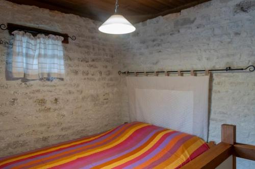 a bedroom with a colorful striped bed in a room at Villa CARAMEL - Piscine - VUE in Fargues