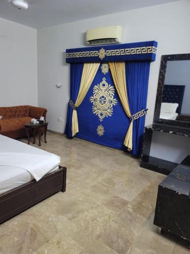 1 dormitorio con cama y cortina azul en Blue diamond guest house en Karachi