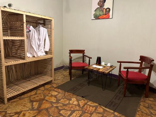a room with a table and two chairs and a table and a tablektop at Afro Smile Hotel & Guest House in Jinja