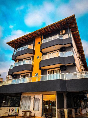 Gravata Praia Hotel - Frente Mar في نافيغانتس: مبنى أصفر طويل مع مقعد أمامه