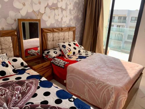 Porto Said Resort Chalet في بورسعيد: غرفة نوم بسريرين ومرآة