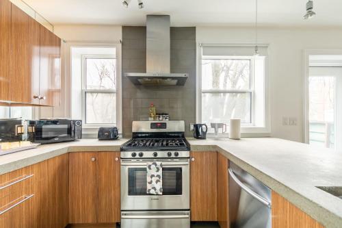 a kitchen with a stainless steel stove top oven at Modern 2 BR Condo - Heart of Leslieville in Toronto