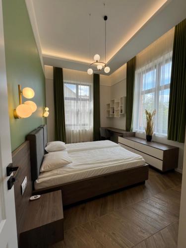 a bedroom with a large bed and two windows at PoshSpot Apartments in Cluj-Napoca