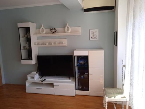 a living room with a tv and a white entertainment center at Nikolic Apartments - Ohrid City Centre in Ohrid