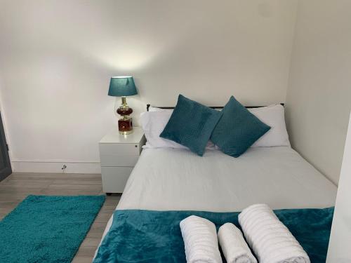 a bedroom with a white bed with blue pillows at Sandra Stay MP in London