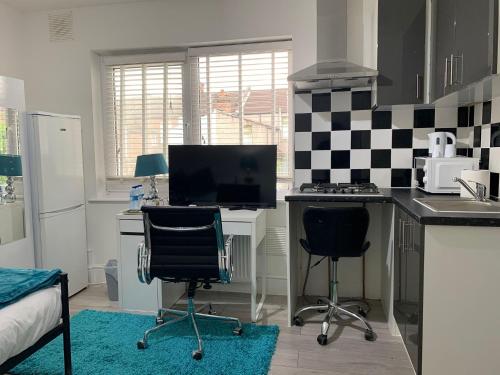 a kitchen with a desk with a computer and two chairs at Sandra Stay MP in London