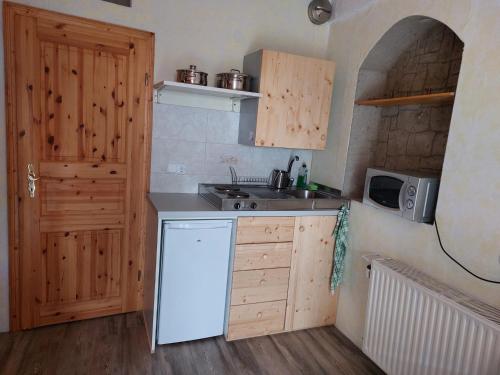 a kitchen with a white refrigerator and a microwave at Ferienzimmer (Stanza) in Fondo Trentino in Fondo