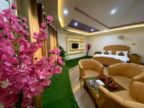 POLO LAND HOTEL Skardu في Tandal: غرفة في الفندق بها سرير وورد أرجواني