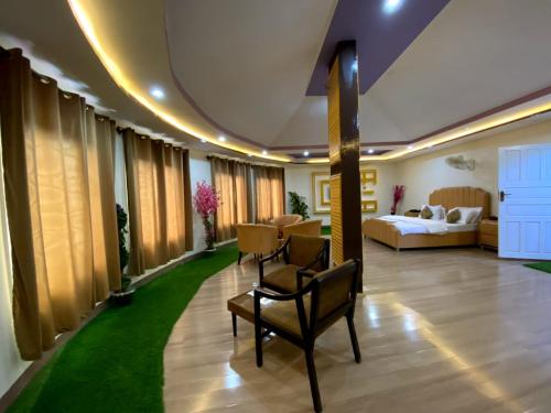 uma sala de estar com um sofá, uma mesa e cadeiras em POLO LAND HOTEL Skardu em Tandal
