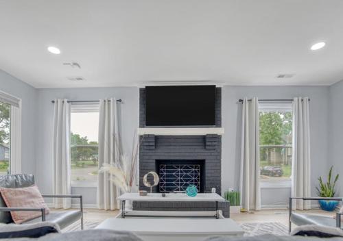 a living room with a fireplace and a flat screen tv at Stylish Home Near Uptown, UNC, and More! in Charlotte