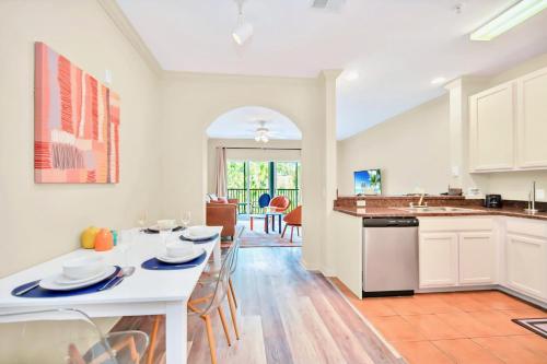 cocina y sala de estar con mesa blanca y sillas en 3BR Condo with Hot Tub and Pool - Near Disney en Orlando