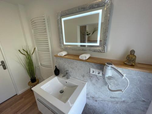 a bathroom with a sink and a mirror at Bergstadt Apartment Lautenthal ,Modern, Stylisch, Geräumig in Lautenthal