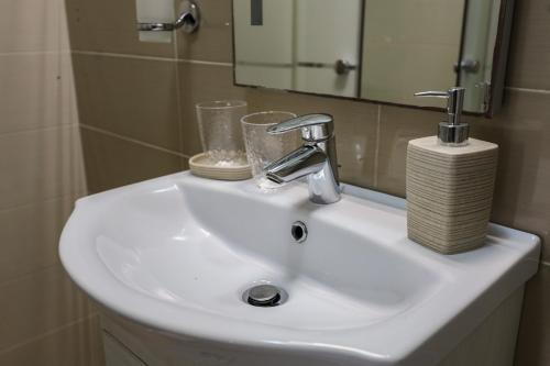 a white sink in a bathroom with a mirror at The Podium Apartment in Żebbuġ