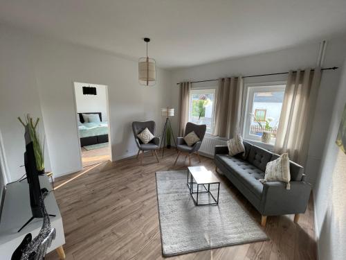 a living room with a couch and a table at Bergstadt Apartment Lautenthal ,Modern, Stylisch, Geräumig in Lautenthal