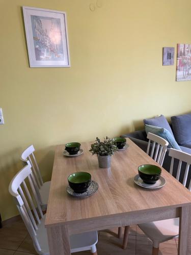 a wooden table with four green bowls on it at Lila's House in Prinos