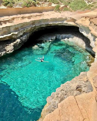 a person on a surfboard in a pool of water at The Podium Apartment in Żebbuġ