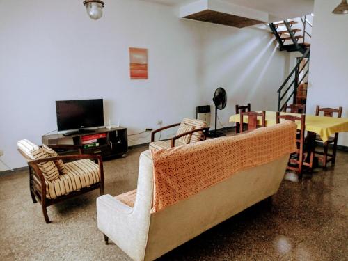 a living room with a couch and chairs and a tv at G Duplex estratégico en ciudad de Mendoza in Mendoza