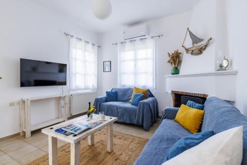 a living room with a blue couch and a table at Marani Home & Villas in Skopelos Town