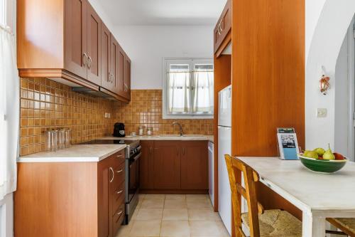 a small kitchen with wooden cabinets and a counter top at Marani Home & Villas in Skopelos Town
