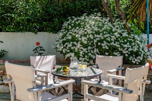 a table and chairs with a table and flowers at Marani Home & Villas in Skopelos Town