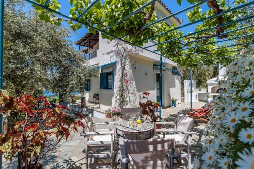 a patio with a table and chairs and trees at Marani Home & Villas in Skopelos Town