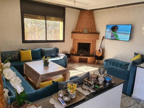 sala de estar con sofás azules y chimenea en Ferme benchriyette, en Cité de Bournazel