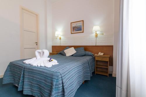 a bedroom with a bed with two towels on it at Apolo Atlantis in Mar del Plata