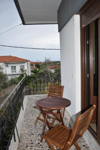 a wooden table and two chairs on a balcony at Lila's House in Prinos