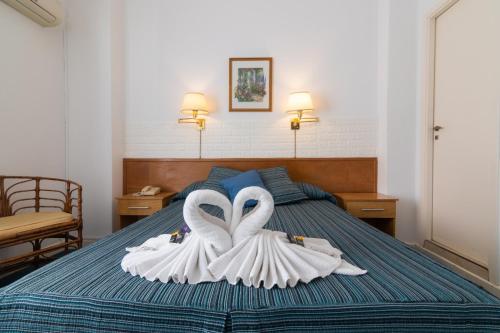 two swans dressed in white are sitting on a bed at Apolo Atlantis in Mar del Plata