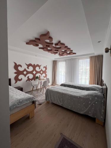 a bedroom with two beds and a chandelier at Tazabek guest house in Kegeti