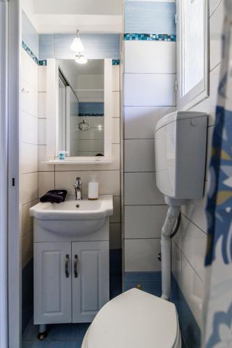 a bathroom with a white toilet and a sink at Marani Home & Villas in Skopelos Town