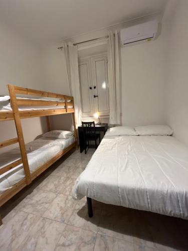 a bedroom with two bunk beds and a table at Scalo 71 GUEST HOUSE in Rome