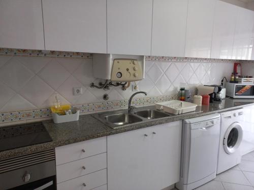 a kitchen with a sink and a washing machine at Barra Atlântica Apartment 1 in Praia da Barra