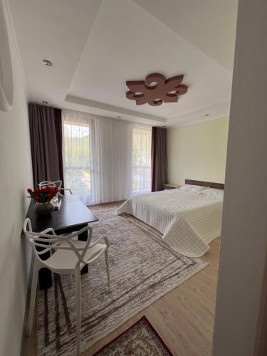 a bedroom with a bed and a table and a chair at Tazabek guest house in Kegeti
