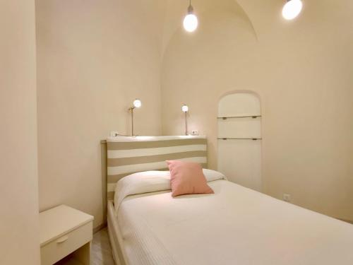 um quarto com uma cama com uma almofada cor-de-rosa em Suite 20 passi dal mare em Laigueglia