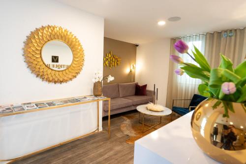 a living room with a couch and a mirror at V Boutique Hotel Böblingen in Böblingen
