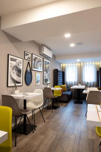 a restaurant with tables and chairs and a couch at V Boutique Hotel Böblingen in Böblingen