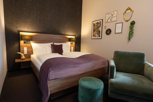 a hotel room with a bed and a chair at V Boutique Hotel Böblingen in Böblingen