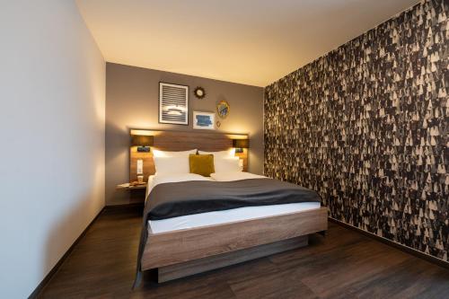 a bedroom with a large bed and a wall at V Boutique Hotel Böblingen in Böblingen