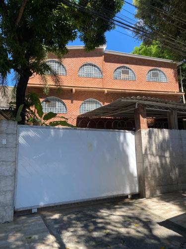 a white fence in front of a brick building at Pousada Solar do Lazer in Recife