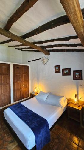 a bedroom with a large white bed in a room at Casa Raisol Barichara in Barichara