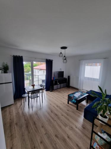 ein Wohnzimmer mit einem Tisch und Stühlen sowie eine Küche in der Unterkunft Apartament Nad Wisłą in Tczew