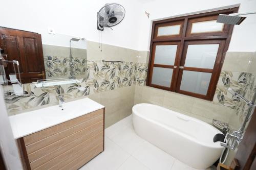 a bathroom with a sink and a toilet and a tub at Jaruv Royal Residencies in Divulpitiya