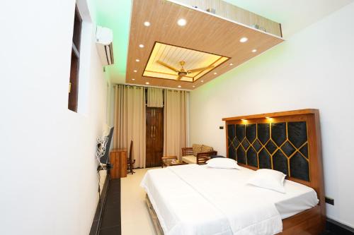 a bedroom with a large white bed in a room at Jaruv Royal Residencies in Divulpitiya