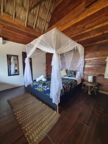 1 dormitorio con 1 cama con dosel en Kite Eco House en Salina de Rey