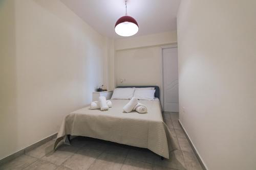 a white bedroom with a bed with white pillows at Villa Infinity View Athens Riviera in Anavissos