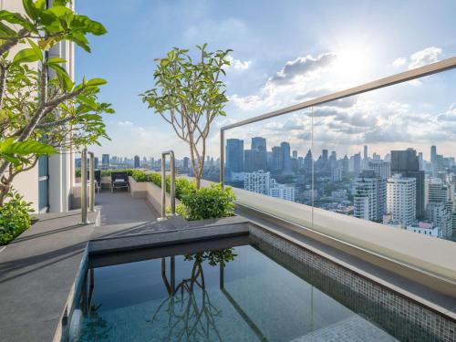 ein Pool auf dem Dach eines Gebäudes mit Skyline der Stadt in der Unterkunft Sofitel Bangkok Sukhumvit in Bangkok