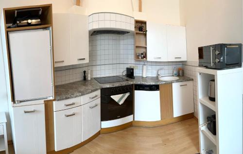 a kitchen with white cabinets and black appliances at Vienna Excellent Apartments in Vienna