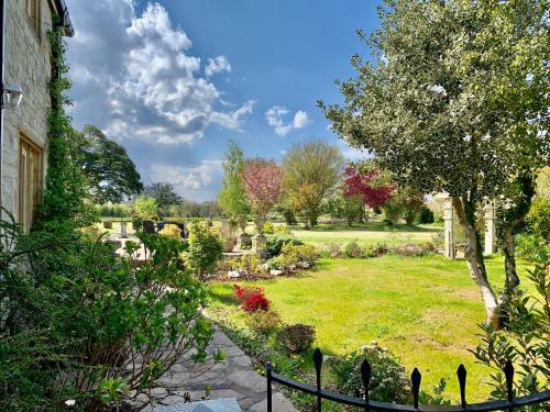un jardin avec une clôture, des arbres et des fleurs dans l'établissement Octon Cottages Luxury 1 and 2 Bedroom cottages 1 mile from Taunton centre, à Taunton